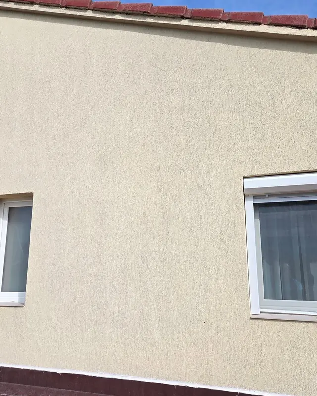 Fațadă bej cu ferestre albe după spălare