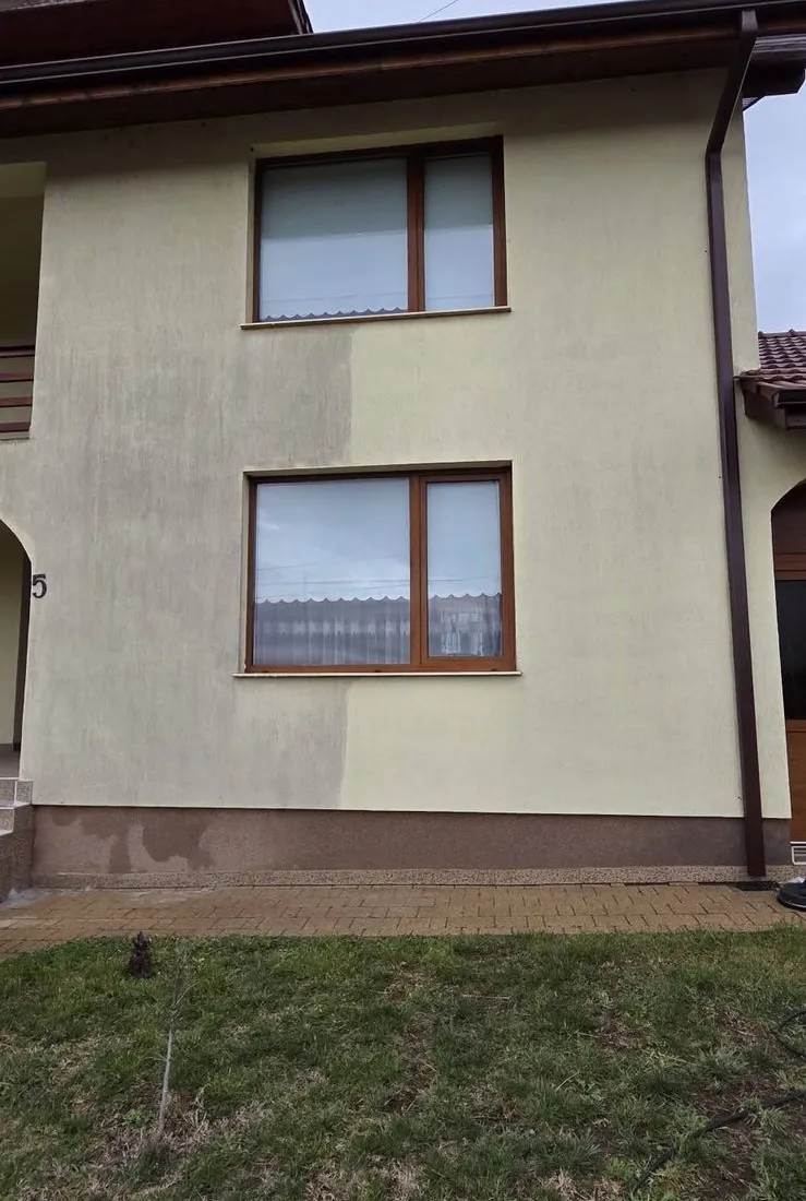Fațadă bej în timpul spălării, cu jumătatea din dreapta deja curățată