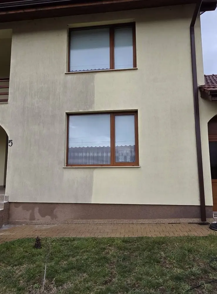 Fațadă bej în timpul spălării, cu jumătatea din dreapta deja curățată
