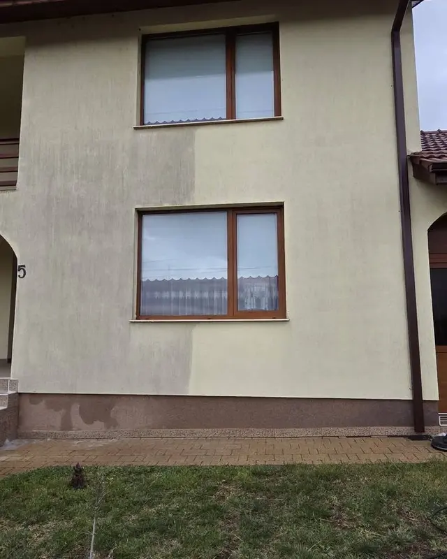 Fațadă bej în timpul spălării, cu jumătatea din dreapta deja curățată