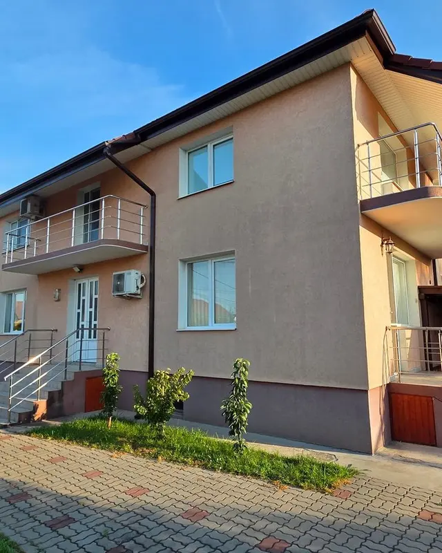 Casa cu fațadă piersică și curtea pavată, după curățare