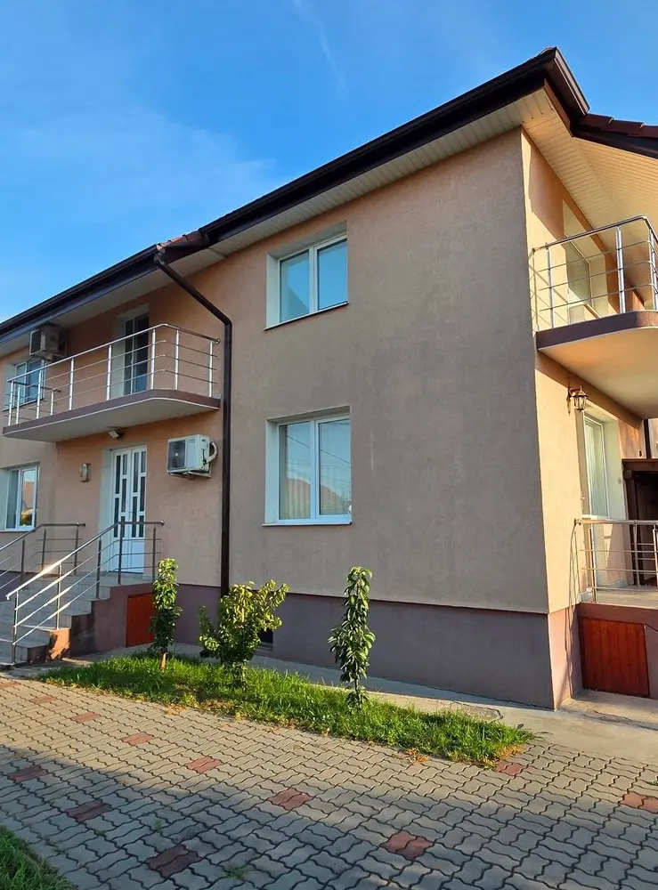 Casa cu fațadă piersică și curtea pavată, după curățare