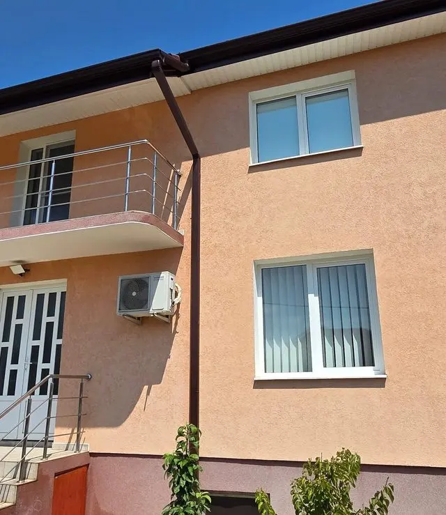 Casă cu etaj și fațadă piersică după spălarea completă a fațadei