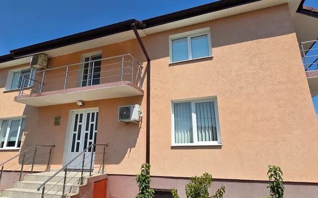 Casă cu etaj și fațadă piersică după spălarea completă a fațadei