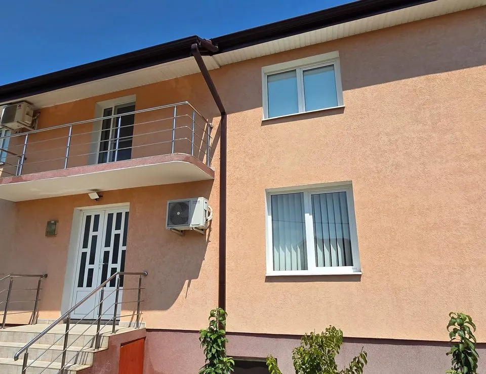 Casă cu etaj și fațadă piersică după spălarea completă a fațadei