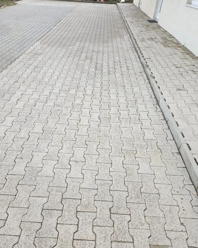 Curte mare pavată lângă o clădire, după spălarea pavajului