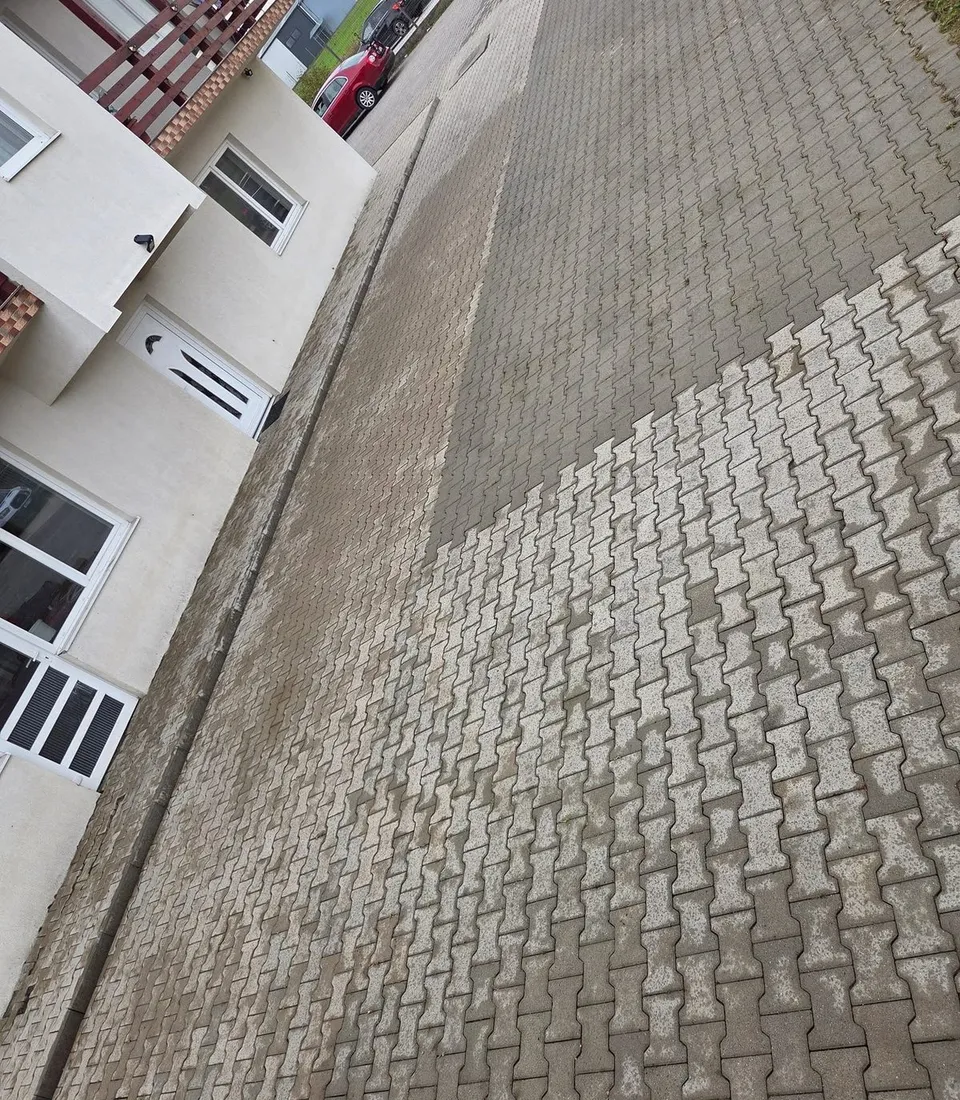 Curte pavată în timpul spălării, cu zona curățată vizibil mai deschisă la culoare