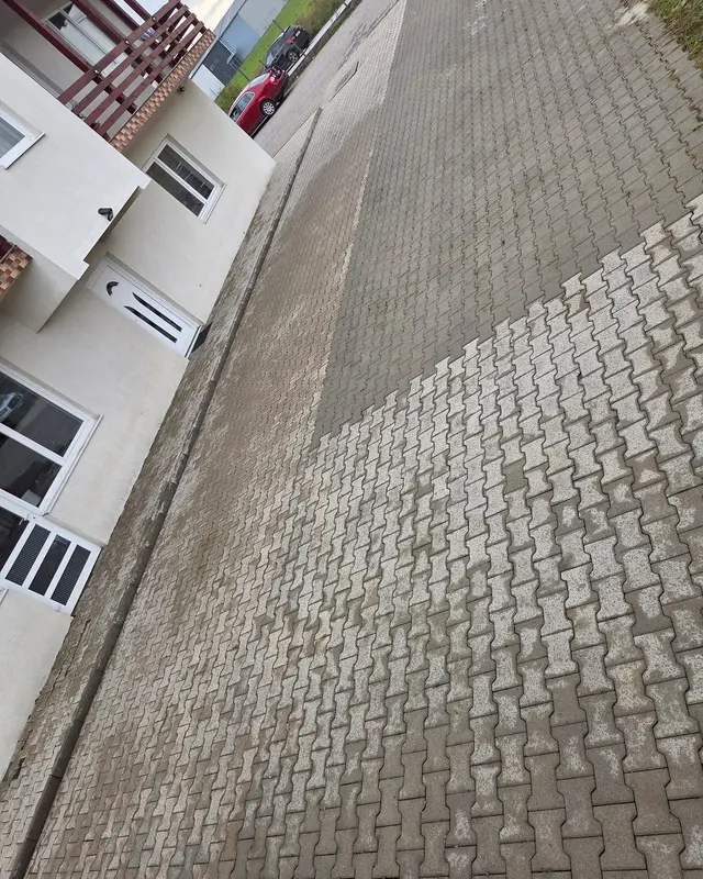 Curte pavată în timpul spălării, cu zona curățată vizibil mai deschisă la culoare